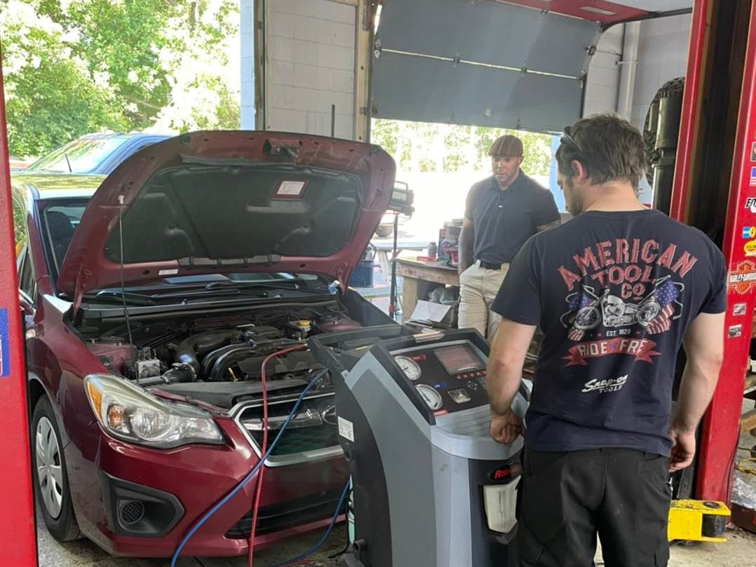 Technician running an A/C recharge machine
